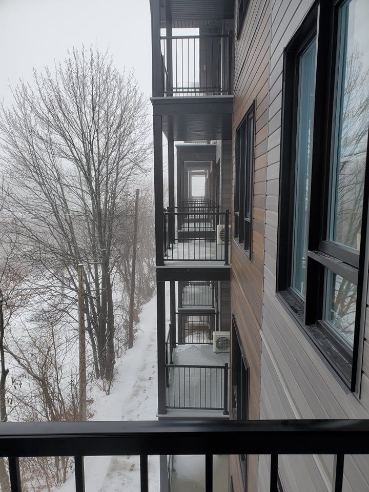 Un bâtiment avec beaucoup de fenêtres et de balcons sous la neige