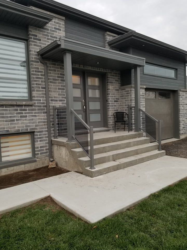 La façade d'une maison en brique avec un porche et des escaliers.