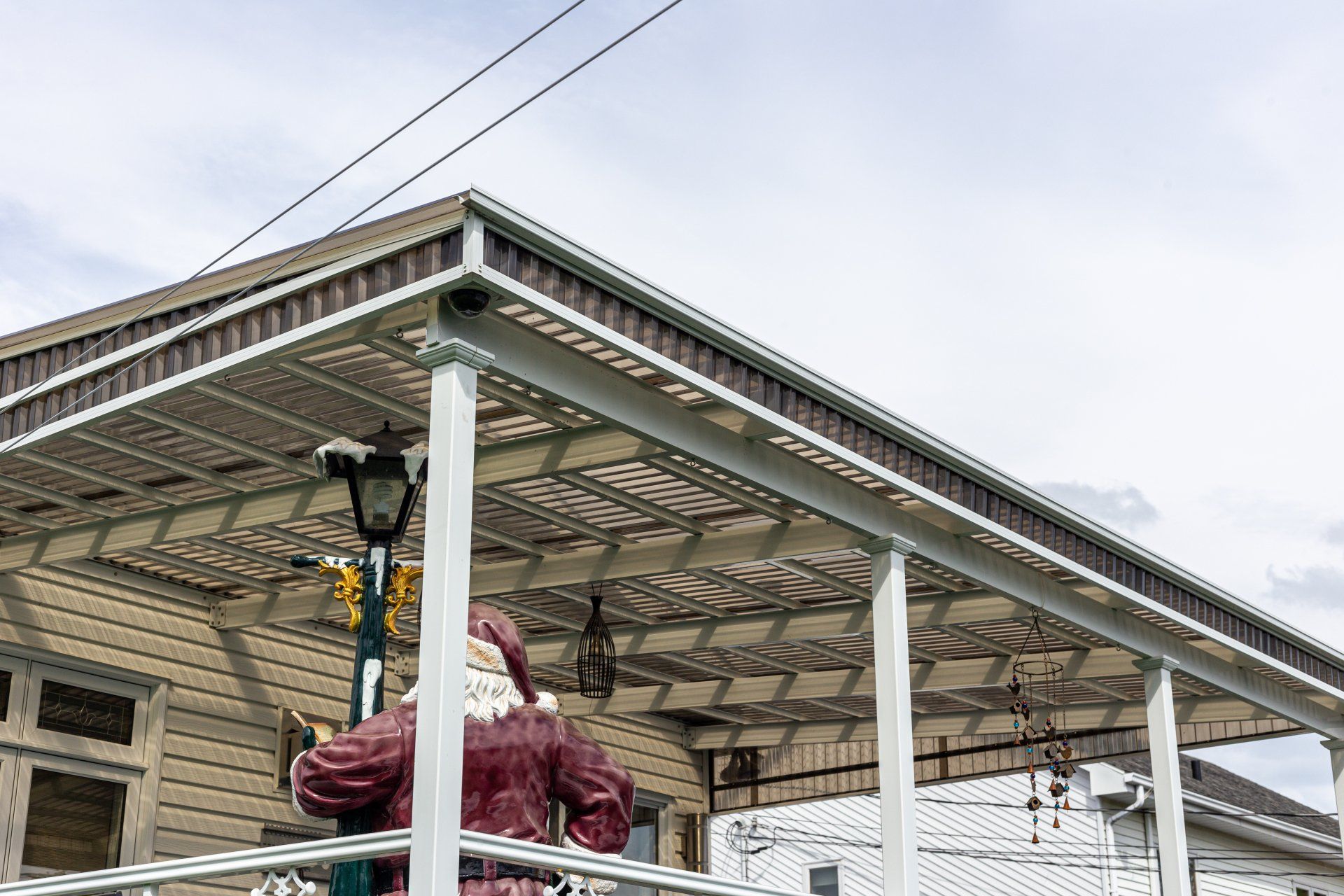 Une statue du Père Noël est assise sur un porche.