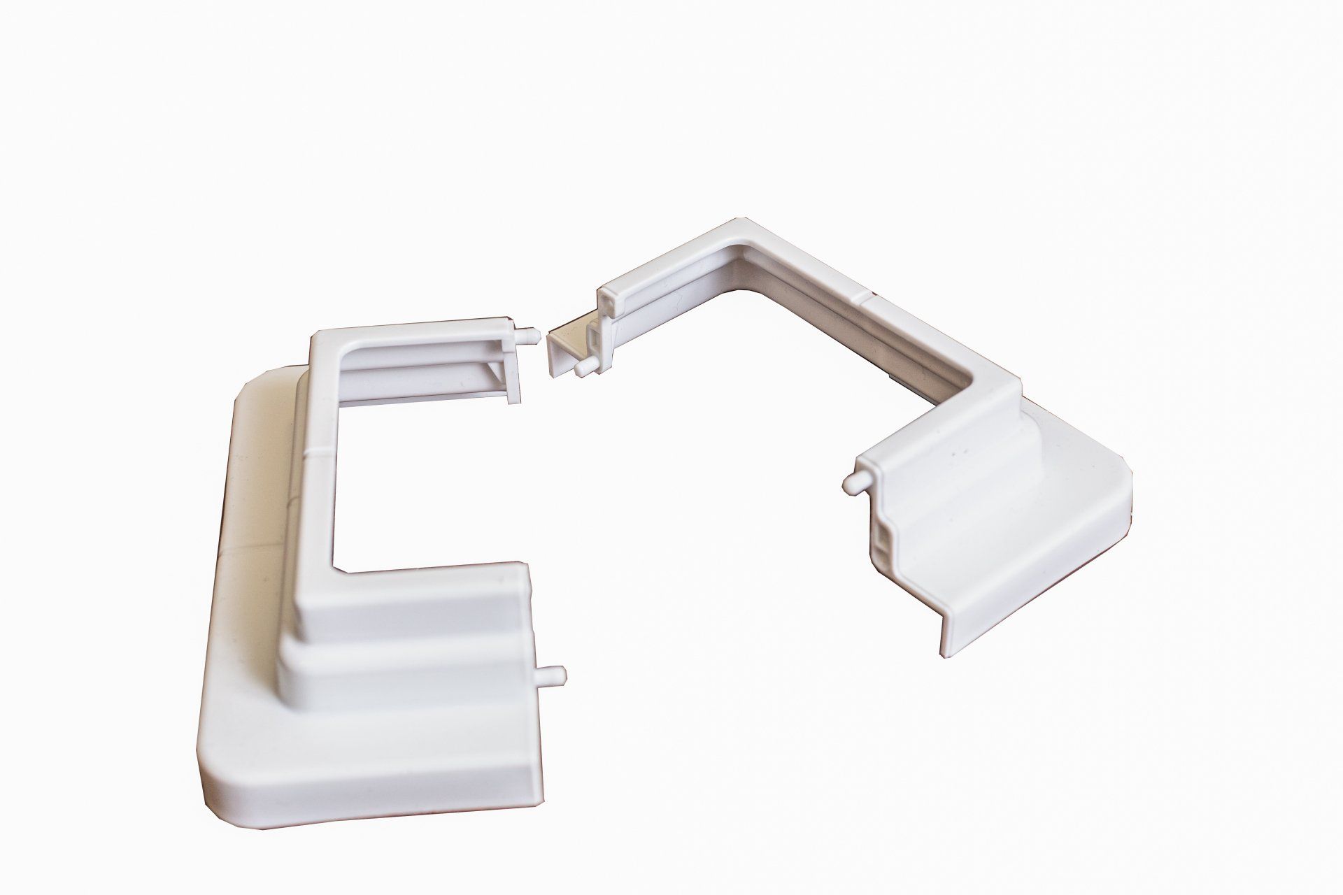 Un objet en plastique blanc est posé sur une surface blanche.