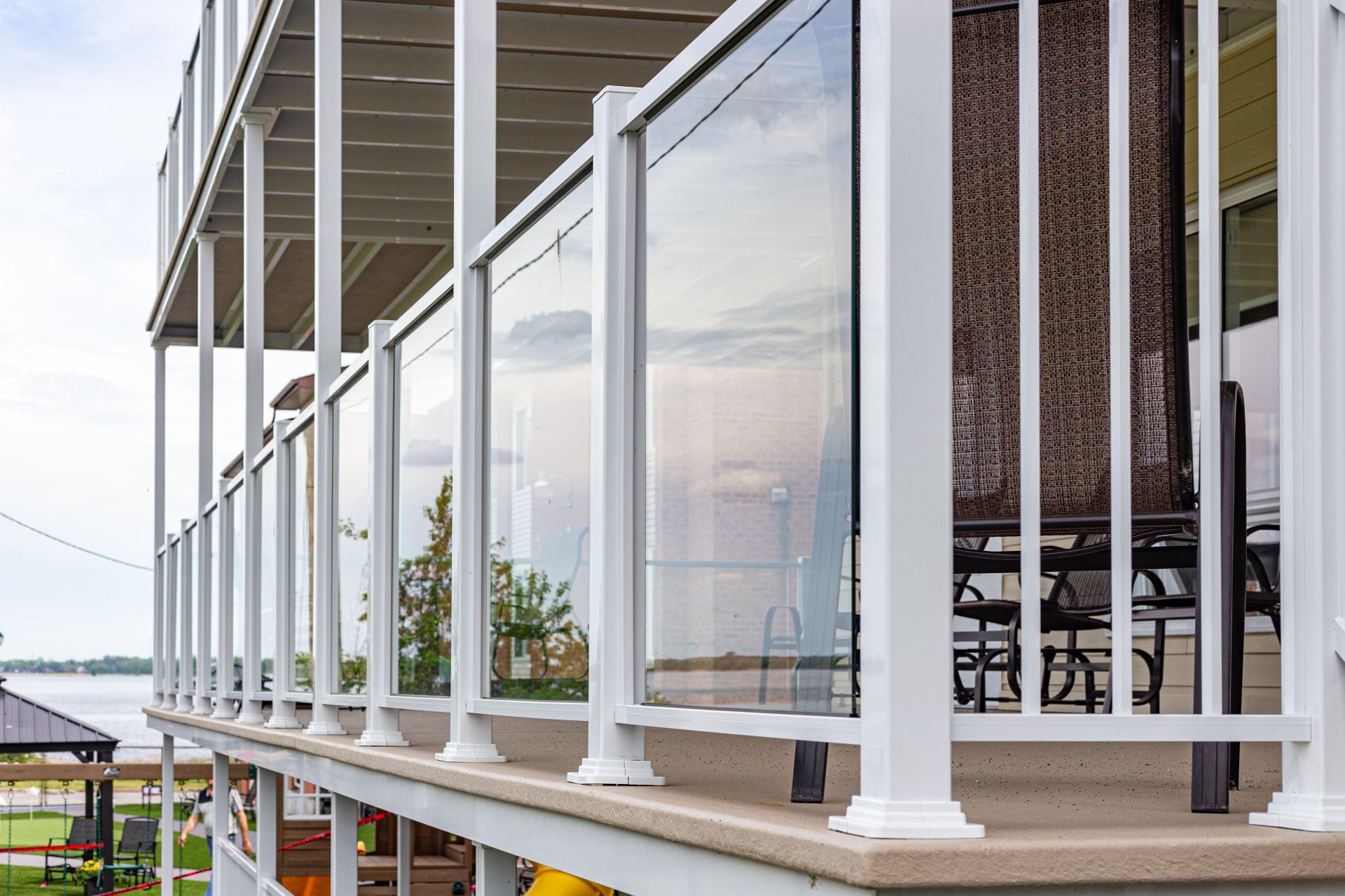 Un balcon avec une balustrade en verre et une vue sur un lac.