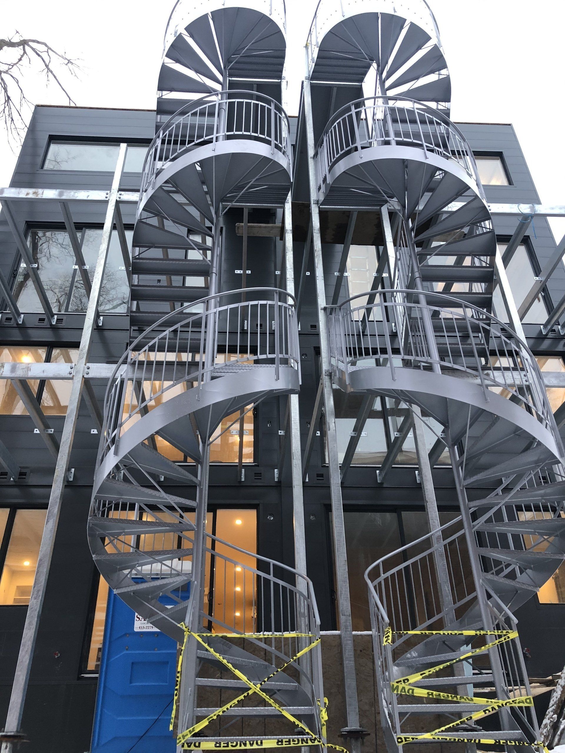 Un escalier en colimaçon est en cours de construction sur le côté d'un bâtiment.