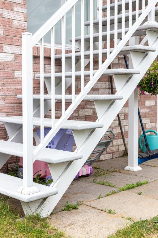 Un ensemble d'escaliers blancs menant à un bâtiment en briques.