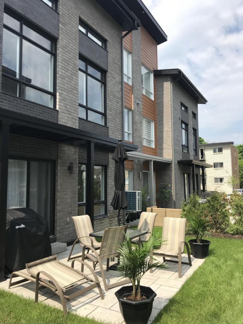 Un patio avec des chaises et une table devant un bâtiment