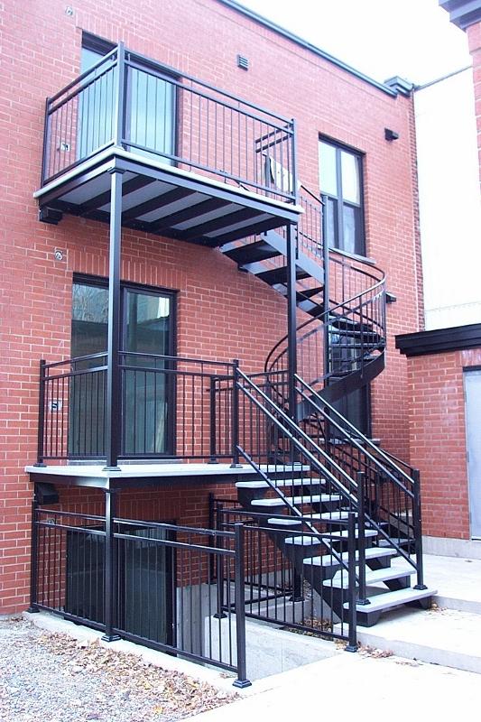 Un bâtiment en briques avec des escaliers menant au deuxième étage