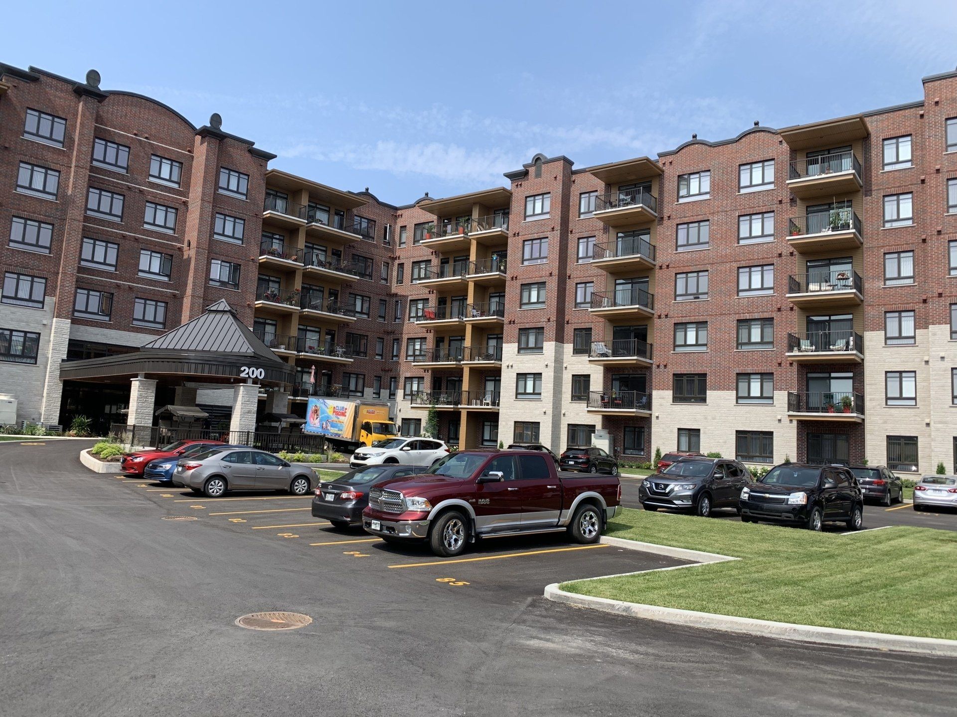 Un grand bâtiment avec beaucoup de voitures garées devant.