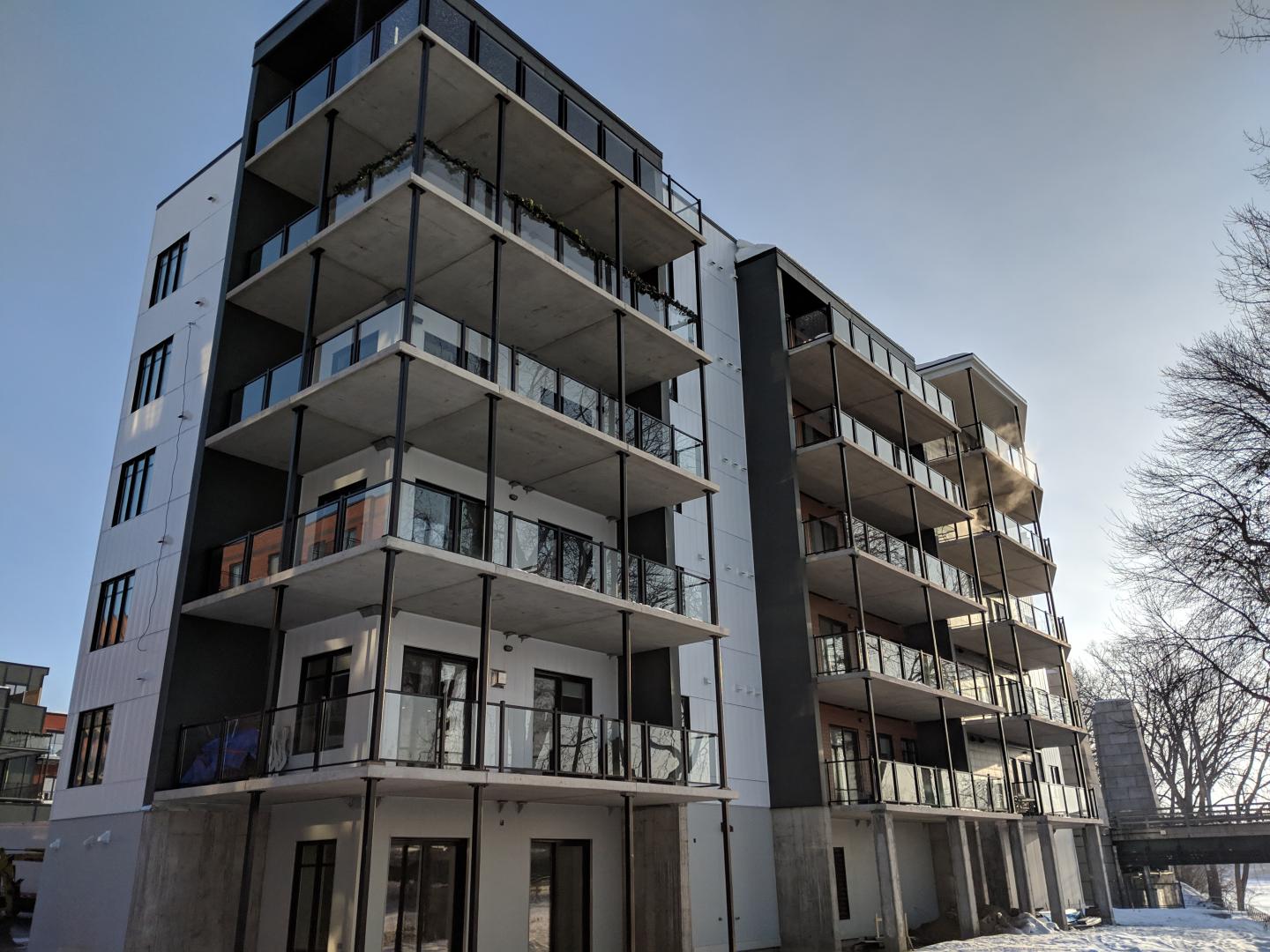 Un grand immeuble d'appartements avec beaucoup de balcons et de fenêtres.