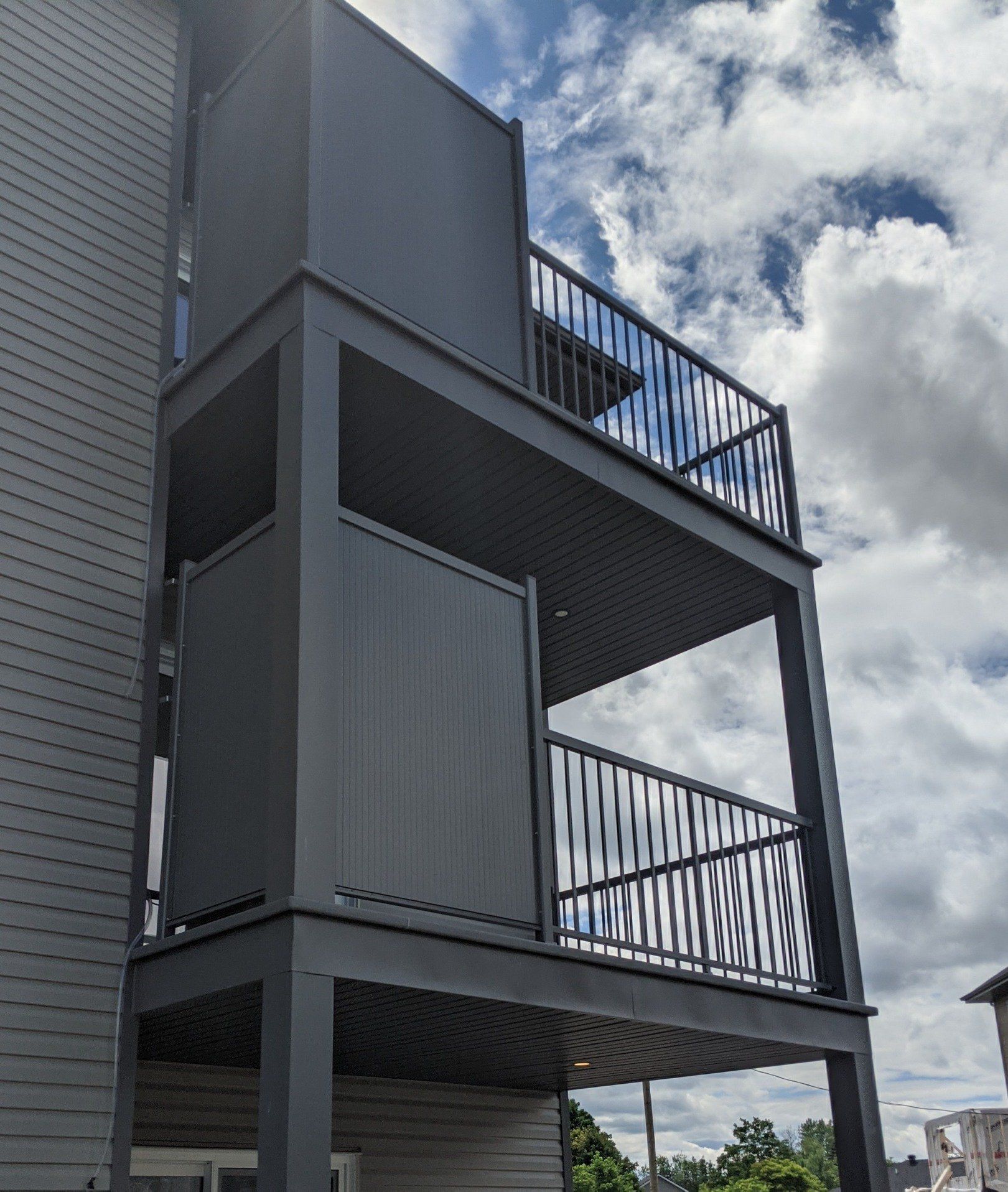 Un balcon sur le côté d'un immeuble avec un ciel nuageux en arrière-plan