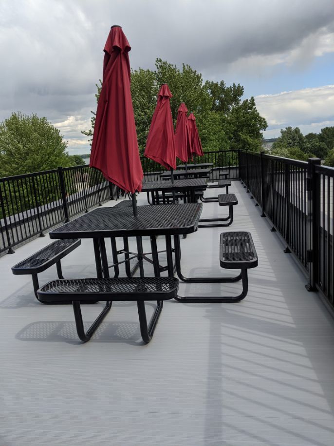 Une rangée de tables de pique-nique avec des parasols rouges
