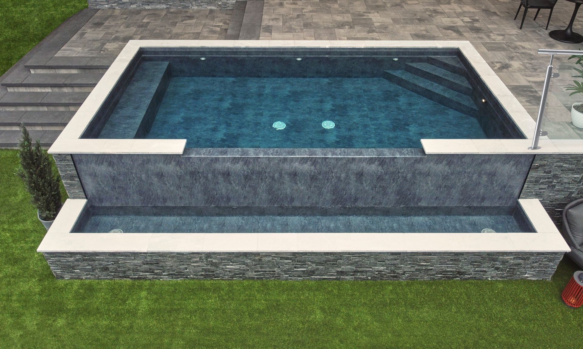 Blue tile pool and hot tub with waterfall and fire features.