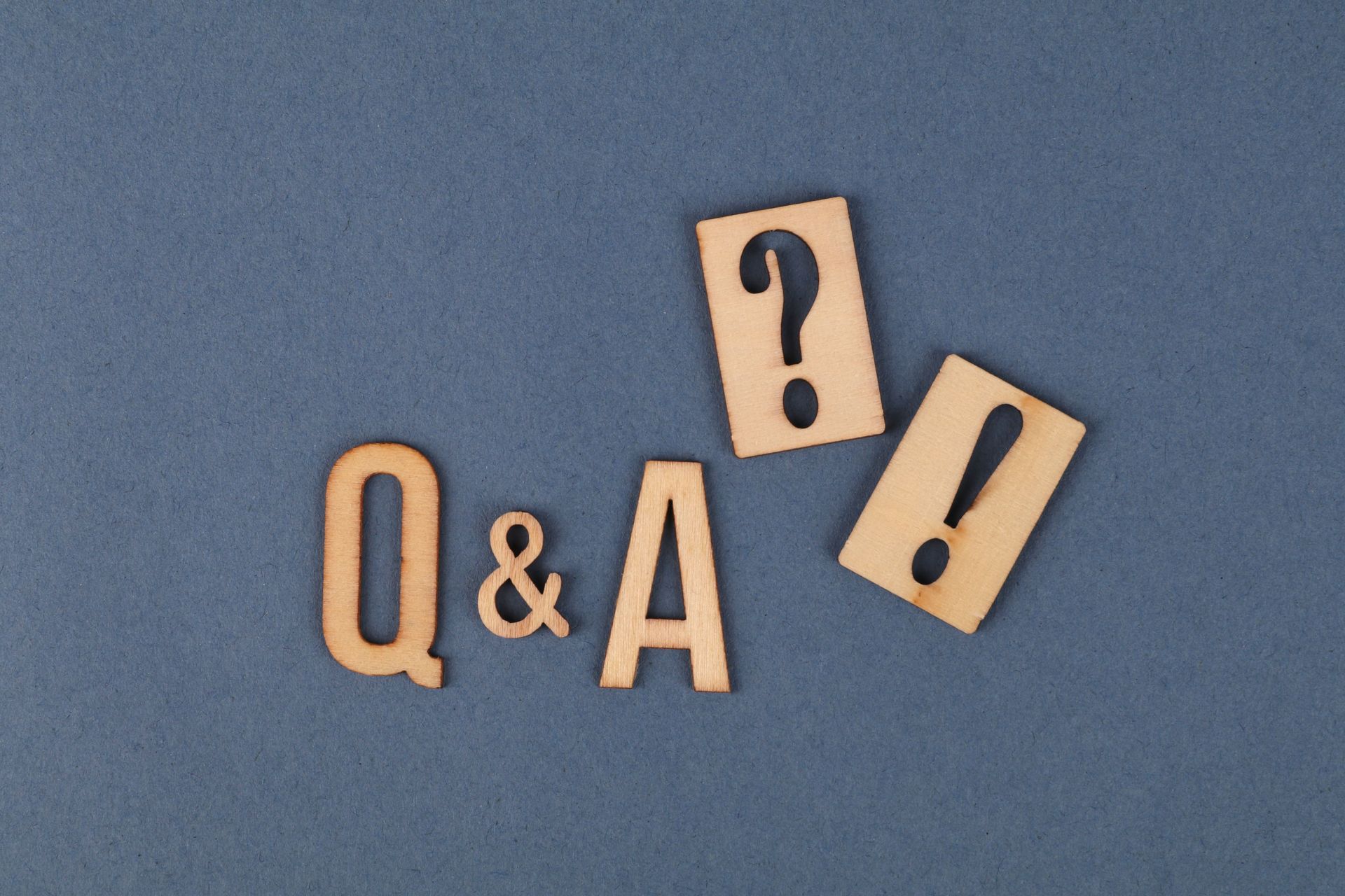 Wooden Q&A letters with a question mark and exclamation mark on a blue background