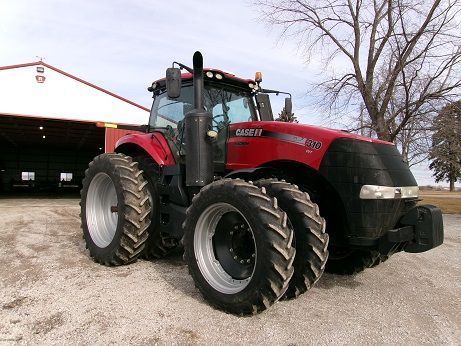 A yellow tractor is parked on a dirt road