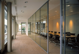 office hallway with windows to the left and glass partitions to the right and table and chairs