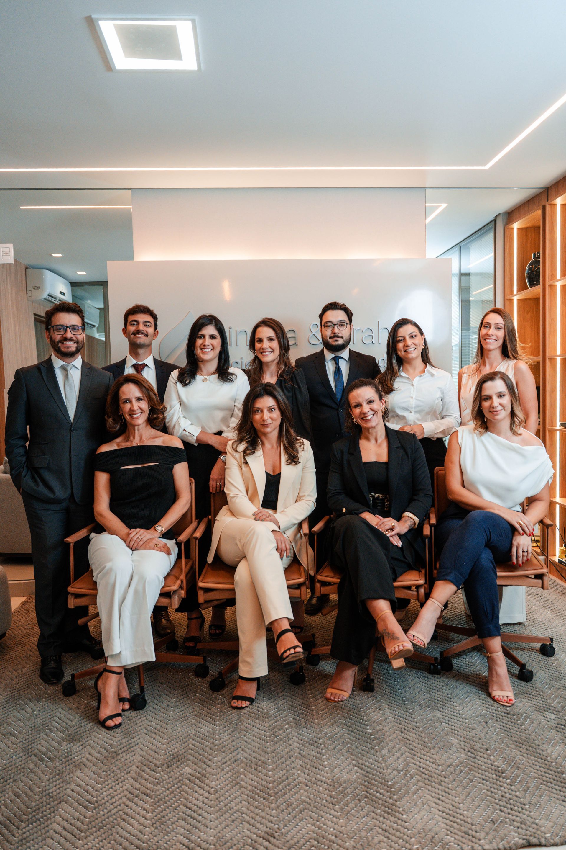 Um grupo de pessoas está posando para uma foto em uma sala.