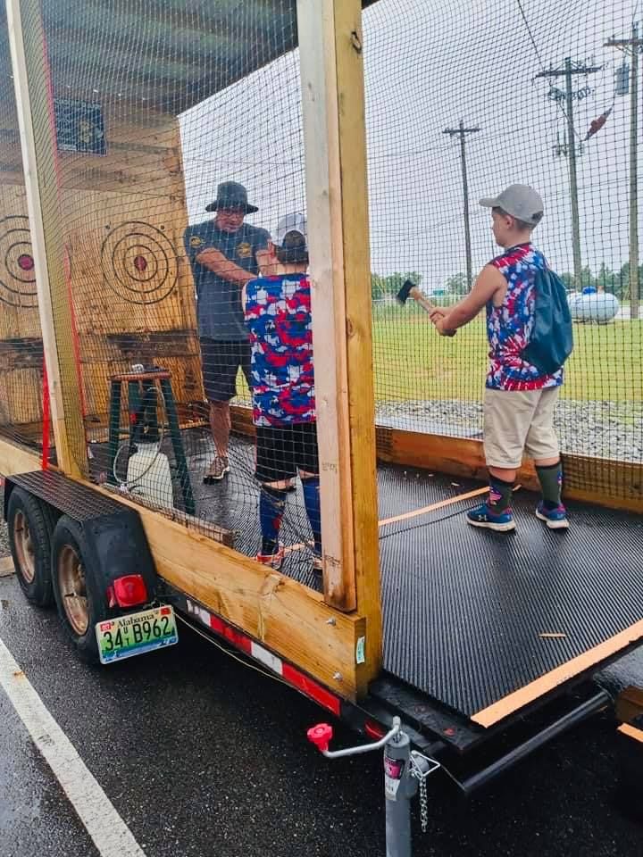 A group of children are playing with axes on a trailer.