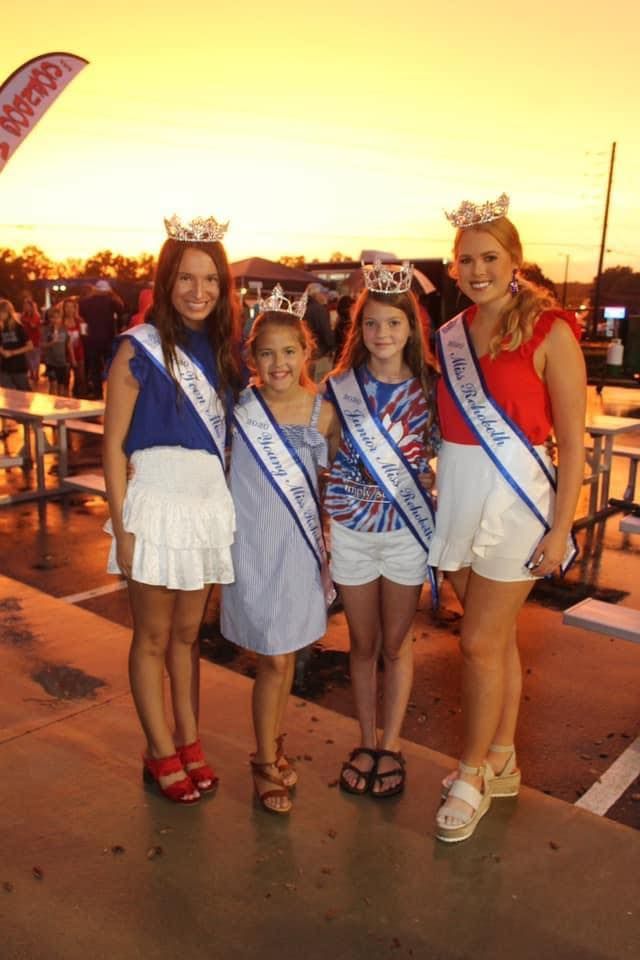 A group of young girls wearing sashes and crowns are posing for a picture.