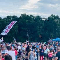 A large group of people are gathered in a park.