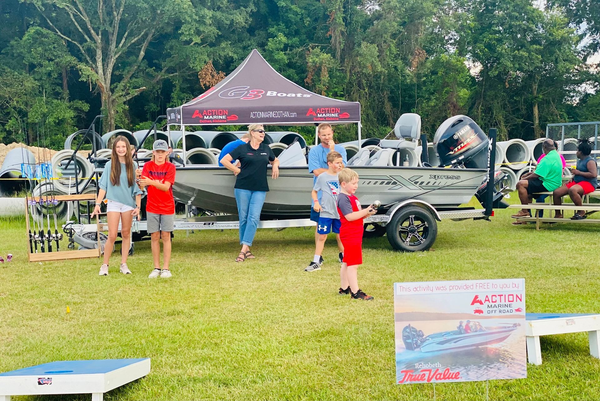A group of people standing in front of a boat on a trailer.