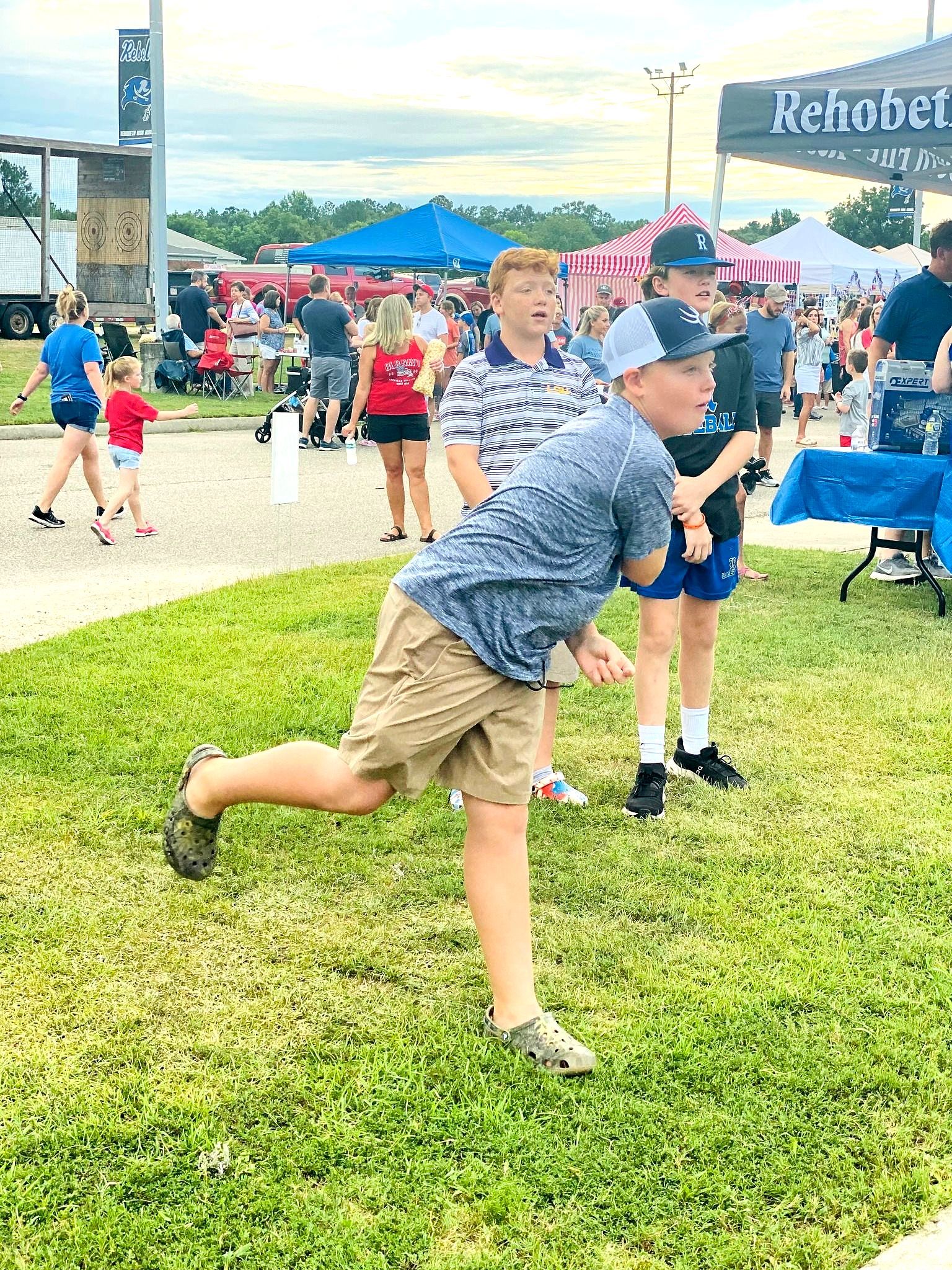 A group of children are playing in the grass at a festival.