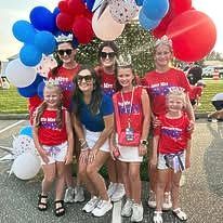 A group of people are posing for a picture with balloons.