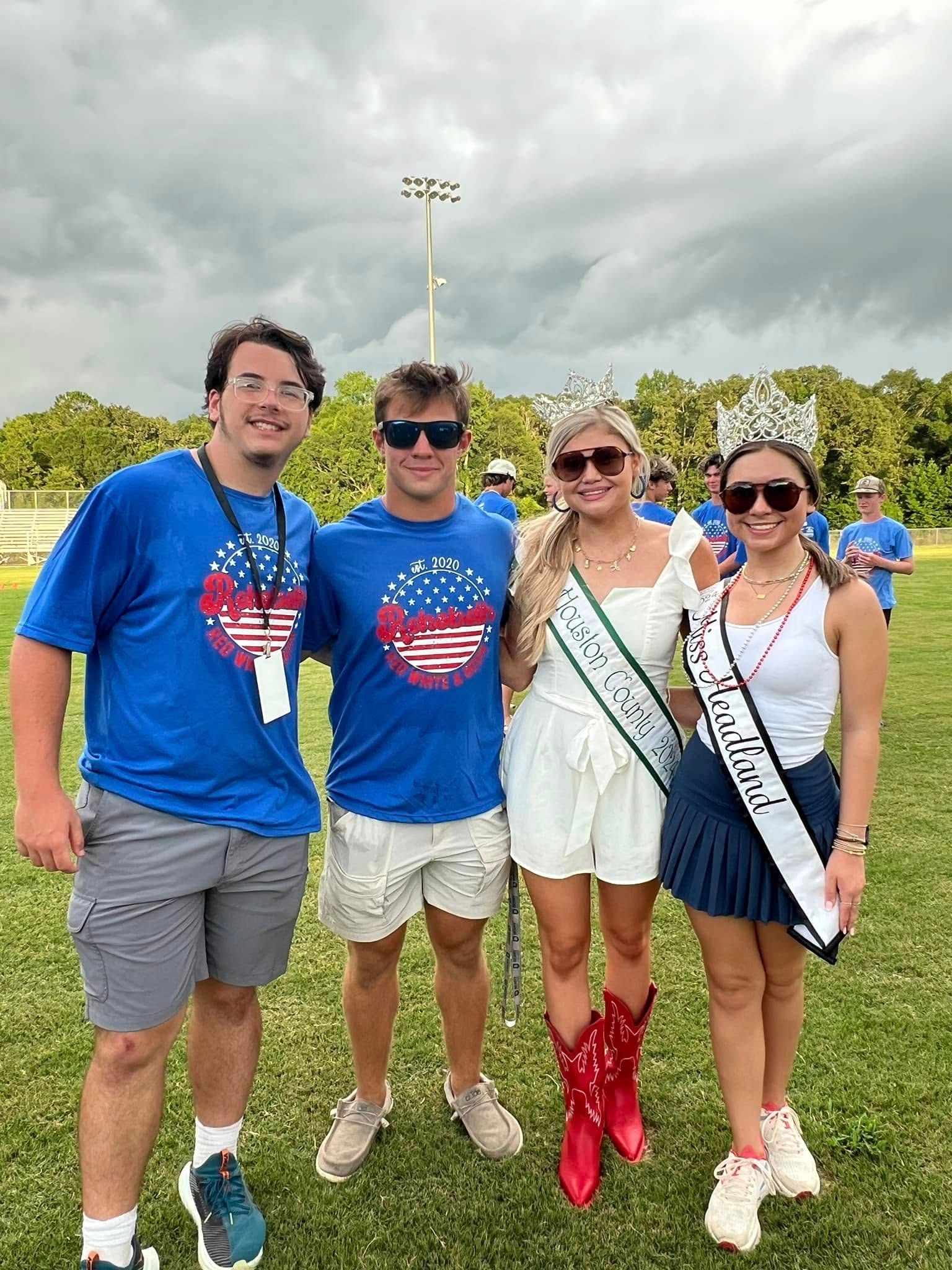 A group of people are posing for a picture in a field.