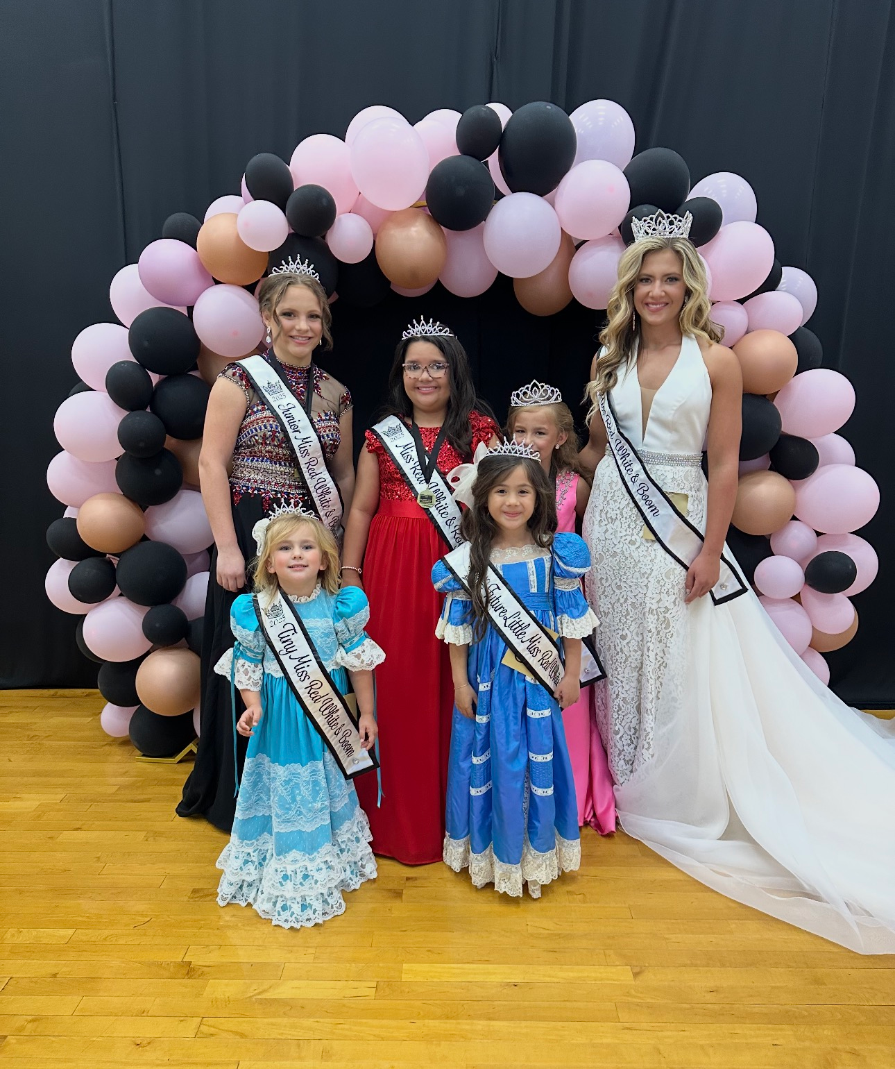 A group of little miss contestants are posing for a picture.