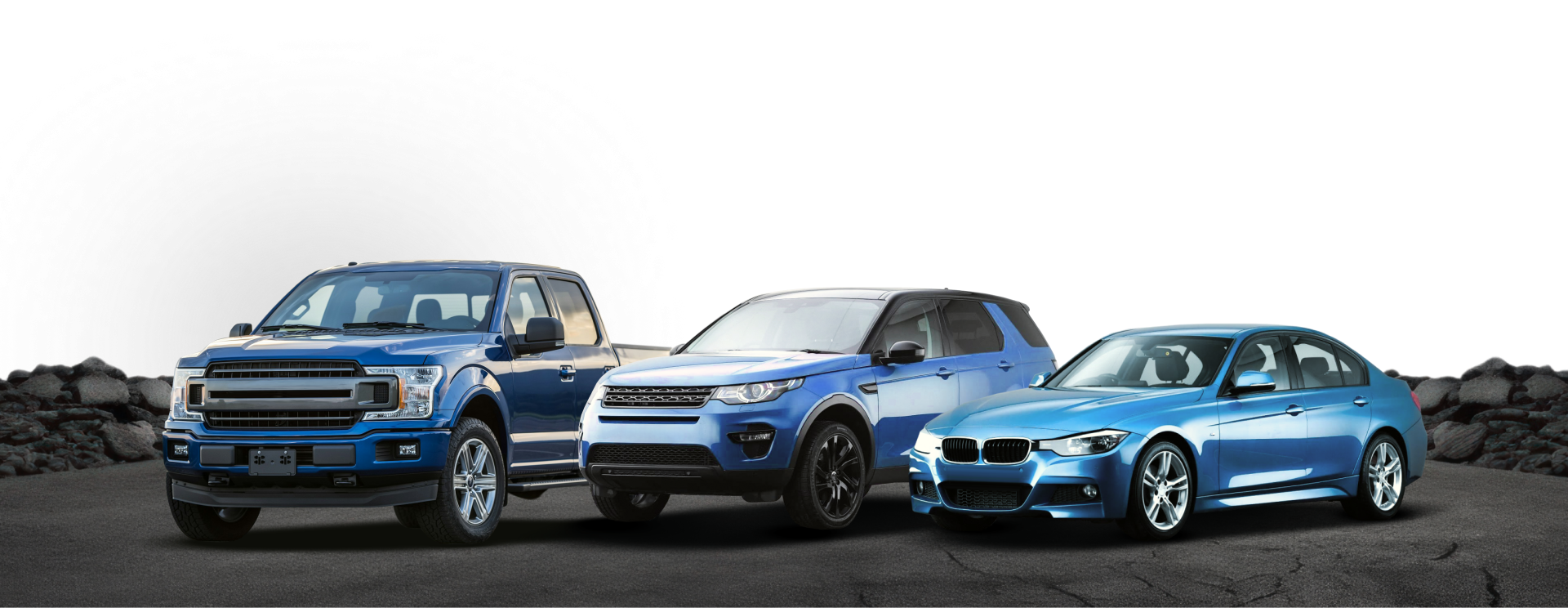 Three blue BMW cars lined up on a rocky road in a dramatic outdoor setting