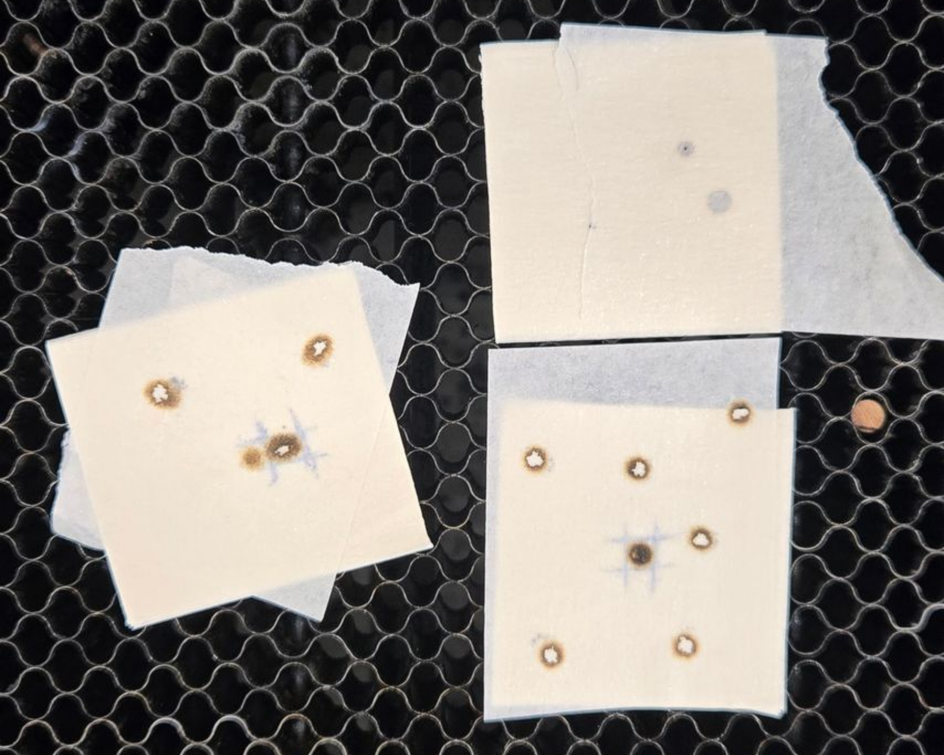 Multiple masking tape targets displaying laser beam alignment test results