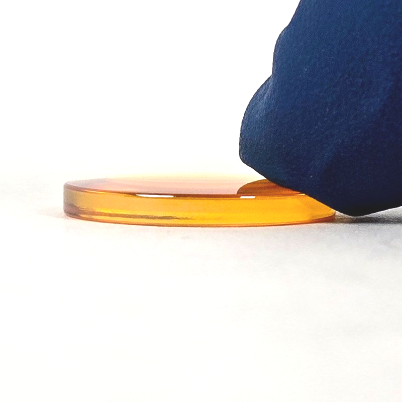 CO2 laser lens placed flat on surface showing correct resting position and lens shape