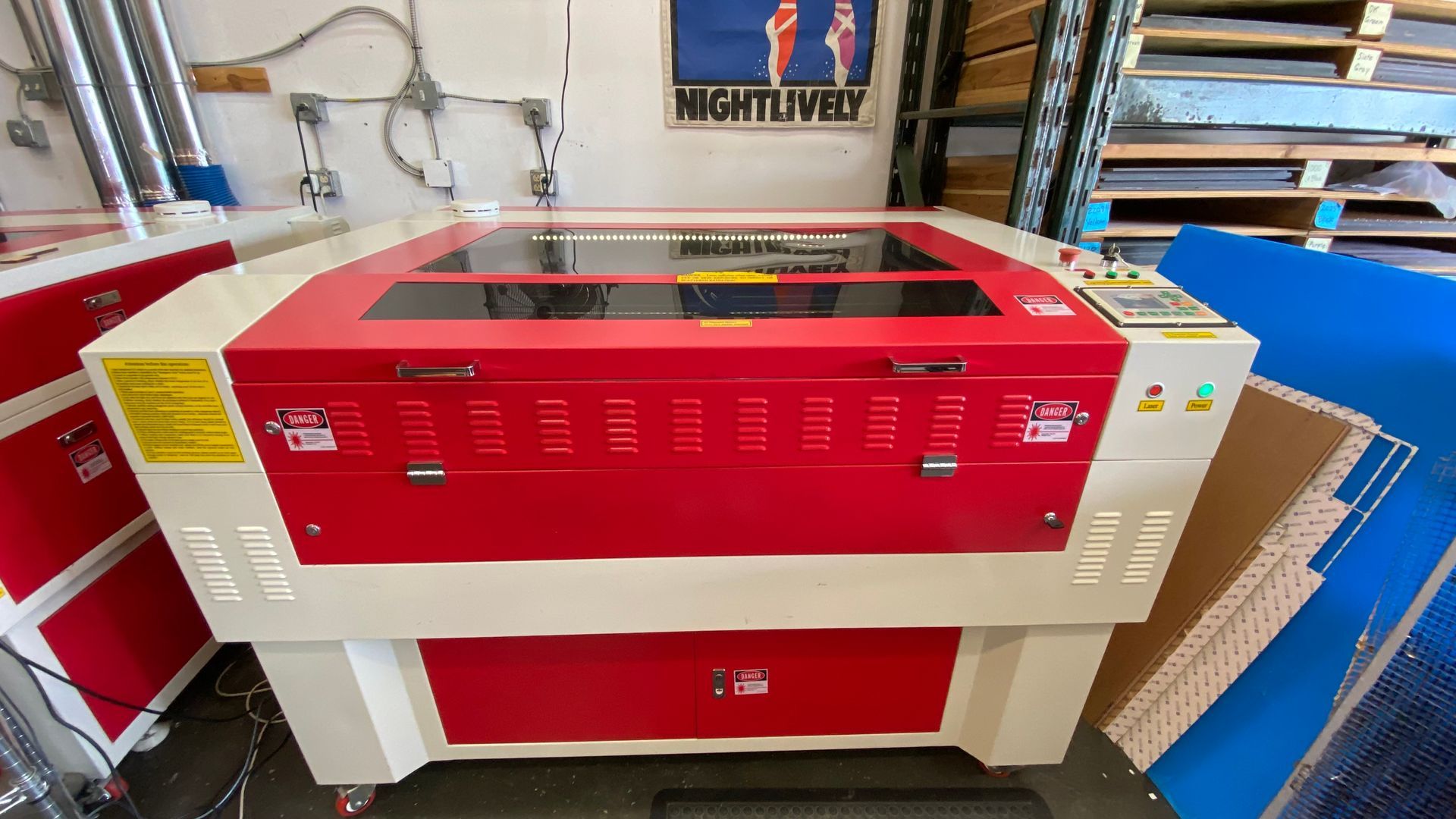 Used RL-80-1290 CO2 laser cutting and engraving machine with red and white enclosed cabinet, front access door, viewing window, and side-mounted control panel.