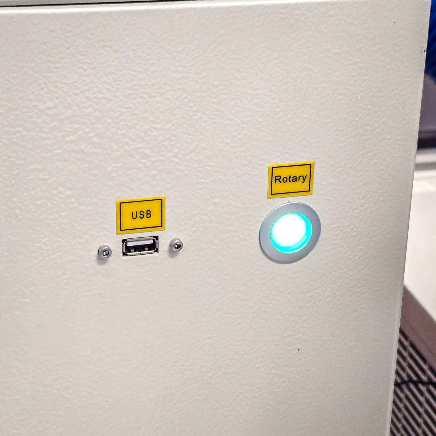 Dedicated Rotary button on Rabbit Laser USA CO2 lasers for quick rotary attachment setup and activation.