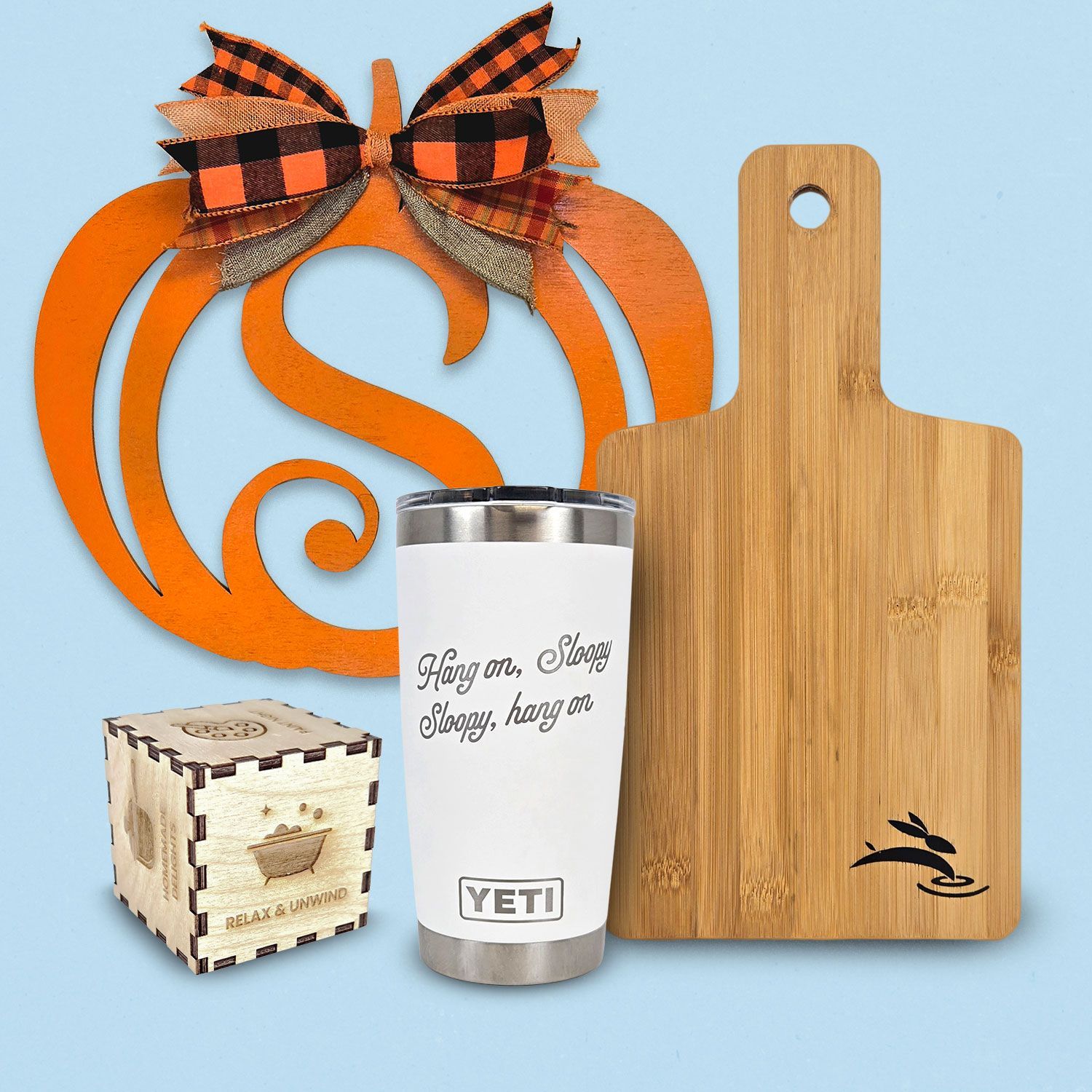 various laser cut and engraved items; tumbler, cutting board, door hanger
