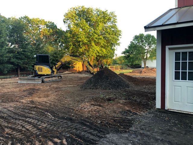 Yellow Excavator is Sitting in a Dirt Field – Elk Grove, CA – AVM Concrete