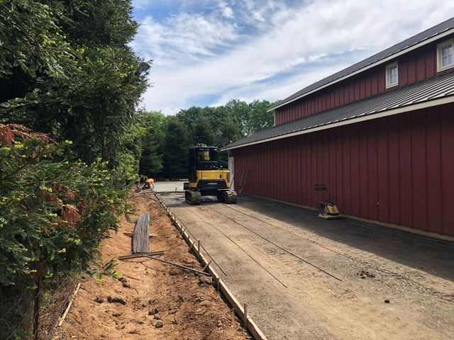 Yellow Excavator is Driving Down a Dirt Road – Elk Grove, CA – AVM Concrete