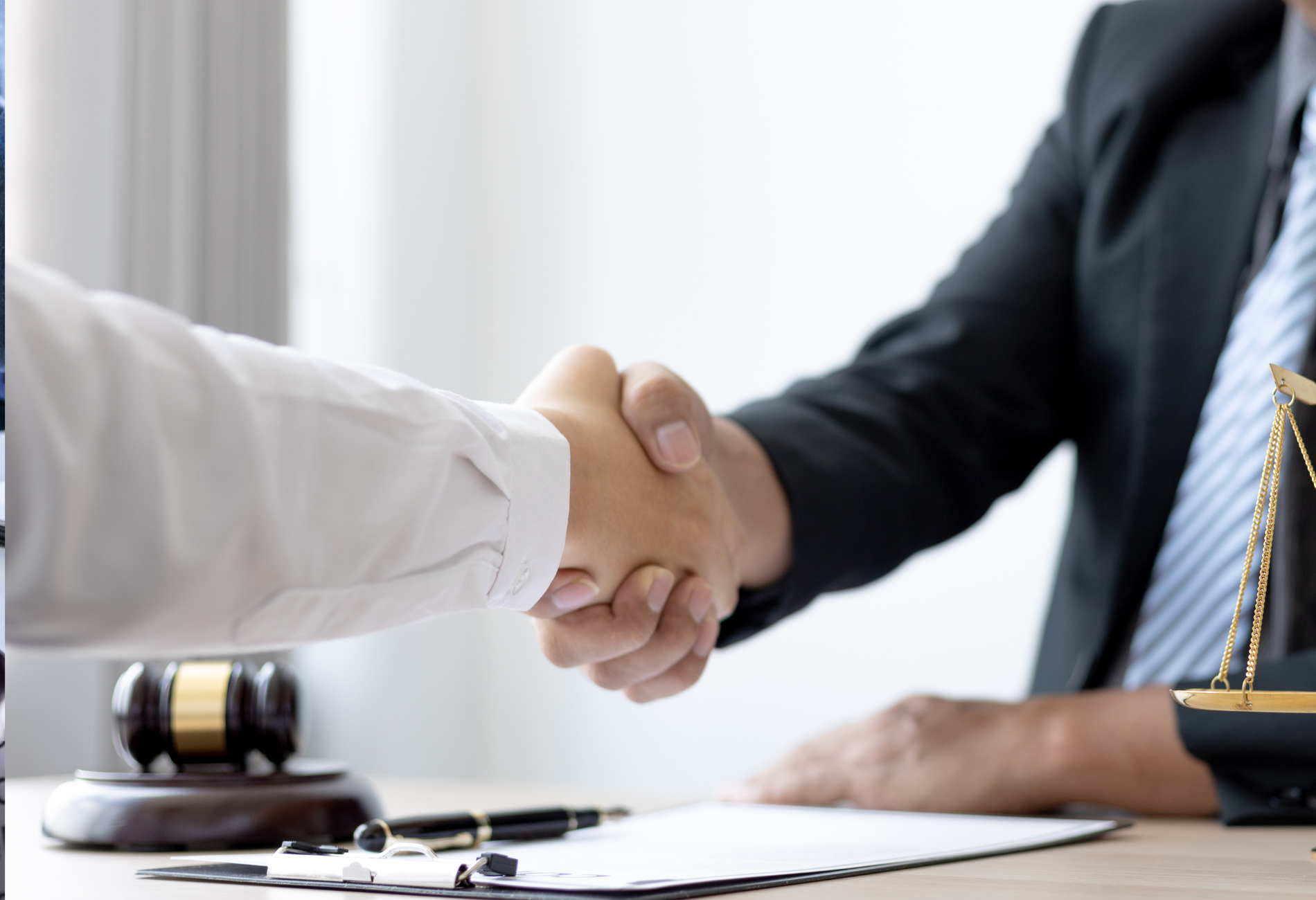 A man in a suit and tie is shaking hands with another man.