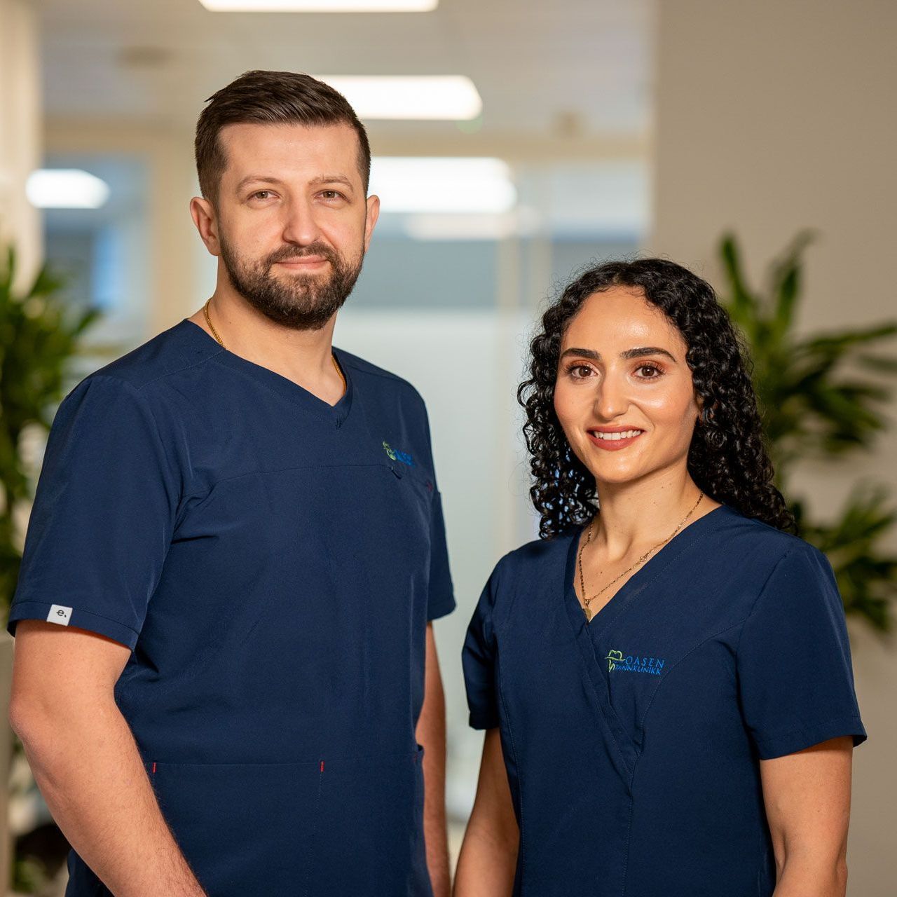 En kvinne sitter i en tannlegestol og snakker med en tannlege.