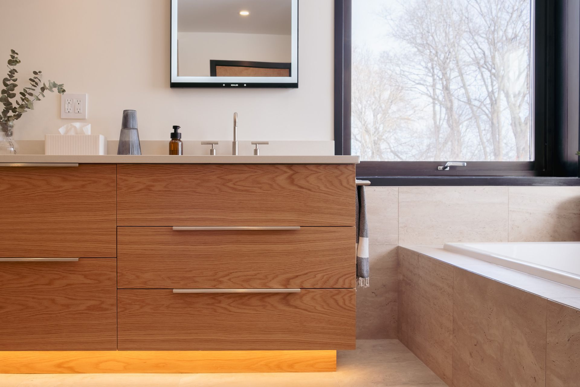 A bathroom with a sink, mirror and tub.