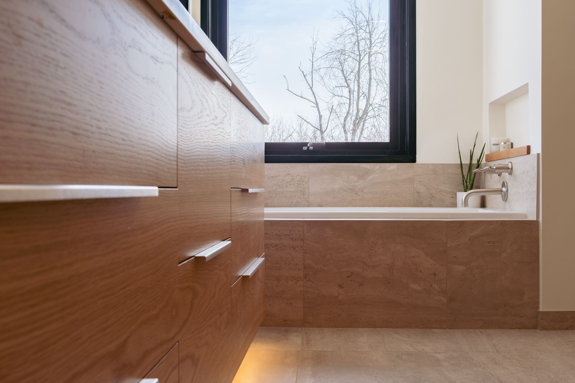 A bathroom with a bathtub and a window.