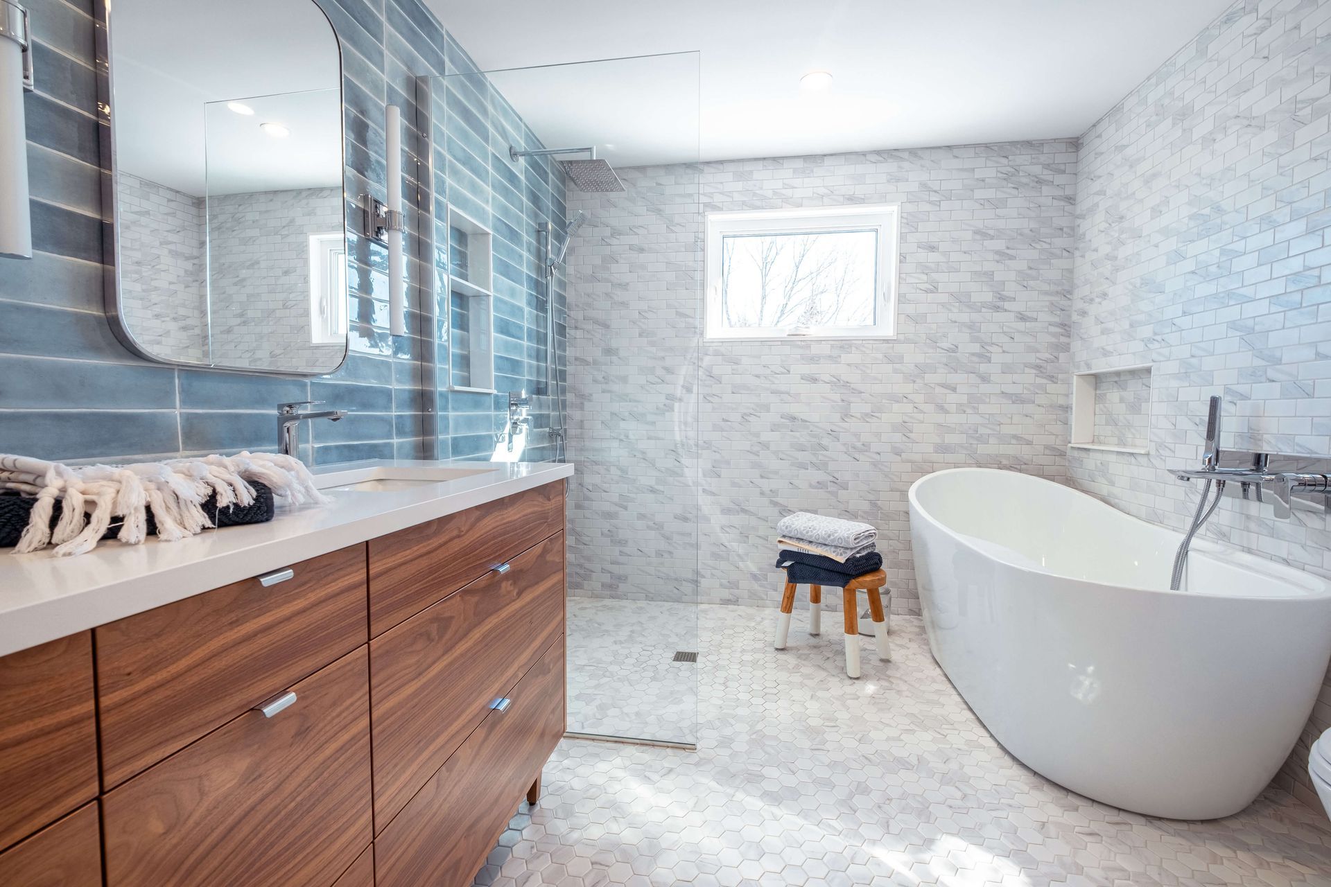 A bathroom with a tub, sink, mirror and walk in shower.