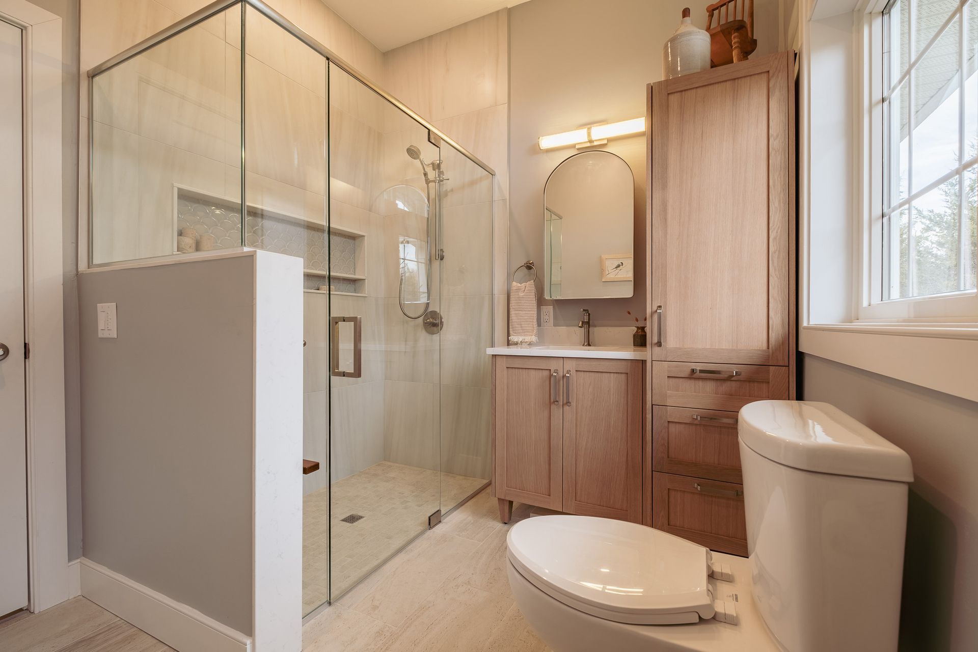 A bathroom with a toilet, sink, and walk in shower.