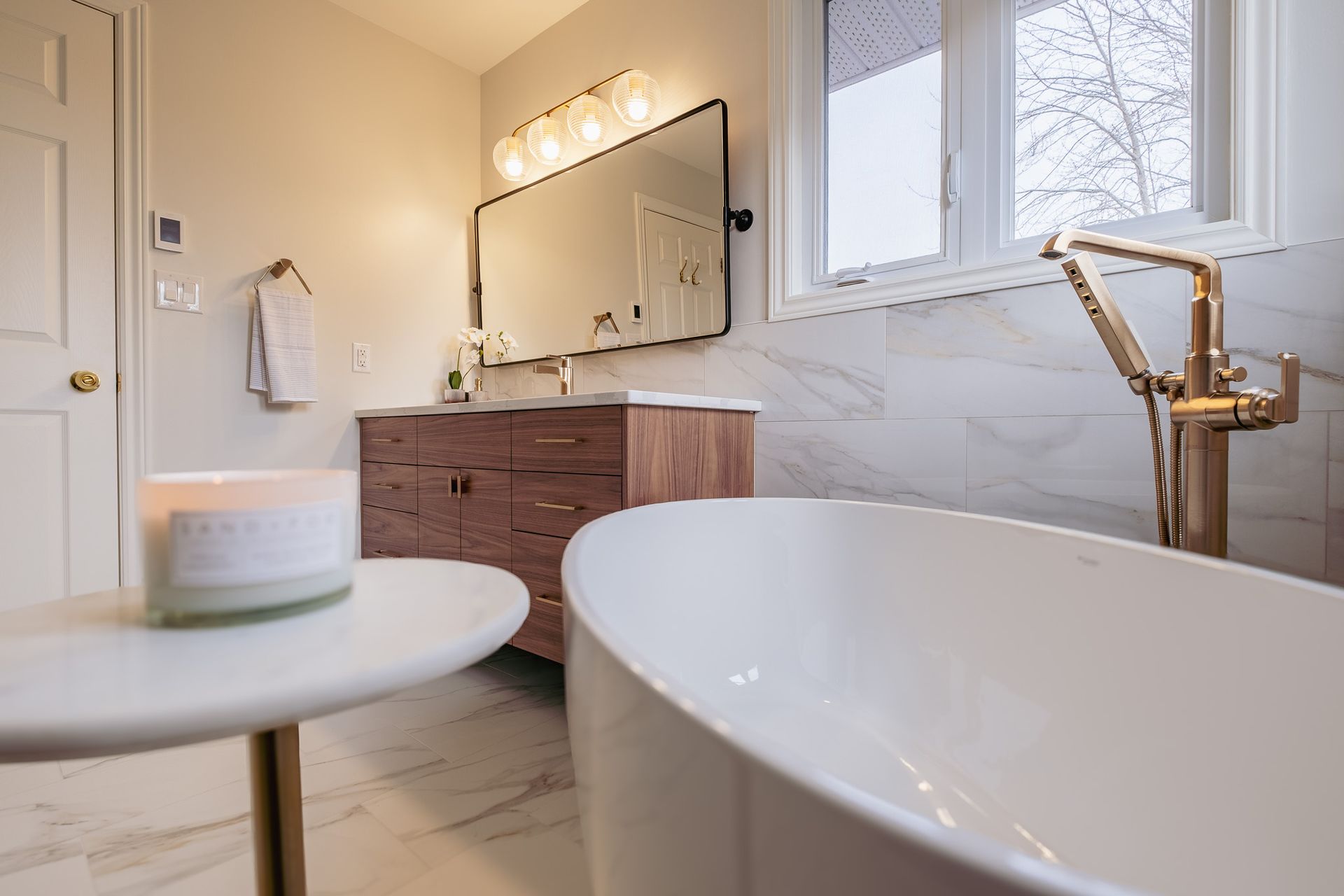 A bathroom with a bathtub, sink and mirror.