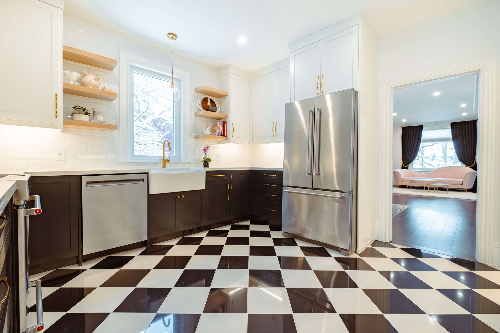 A kitchen with black and white checkered floors and stainless steel appliances.