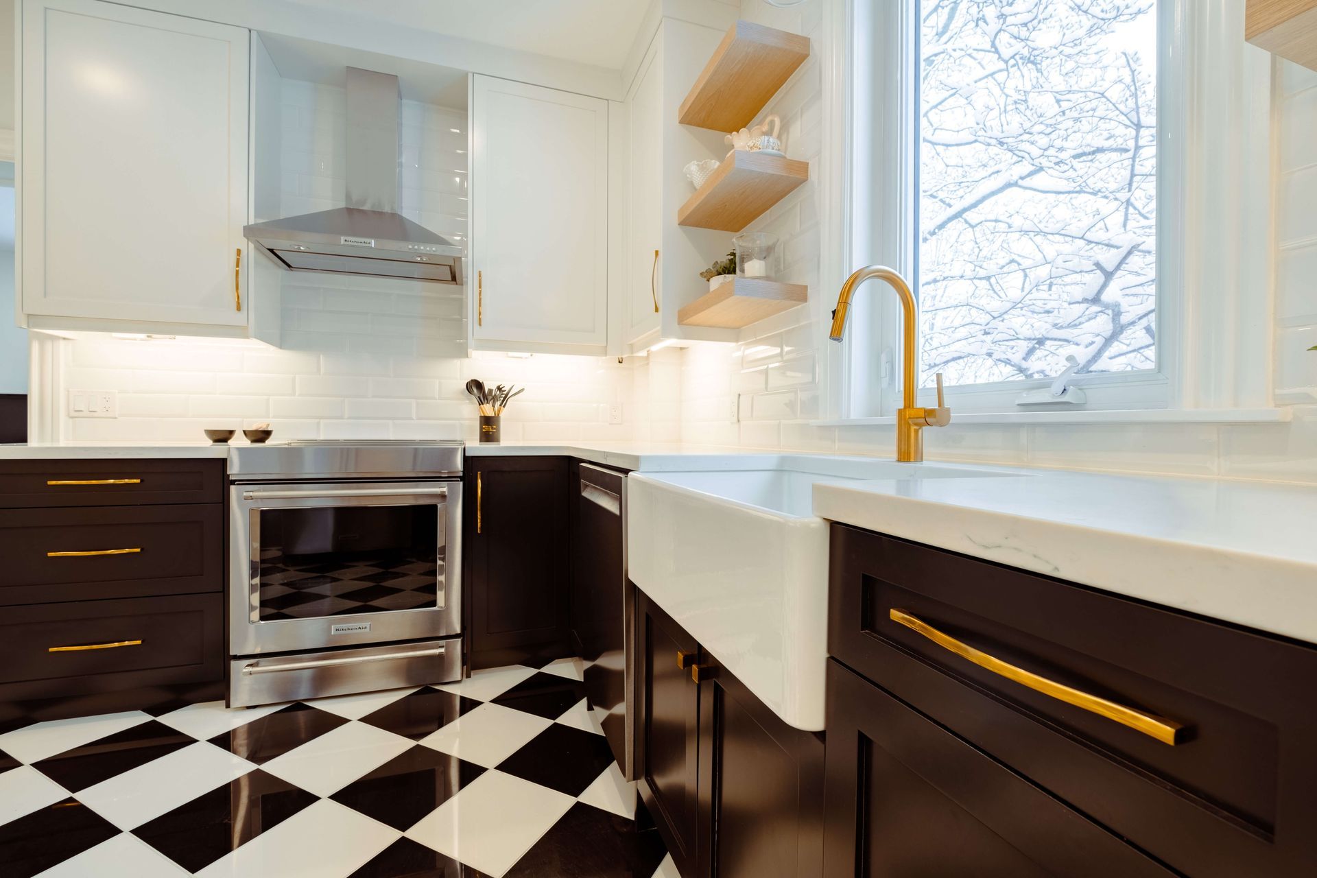 A kitchen with black cabinets and a checkered floor.