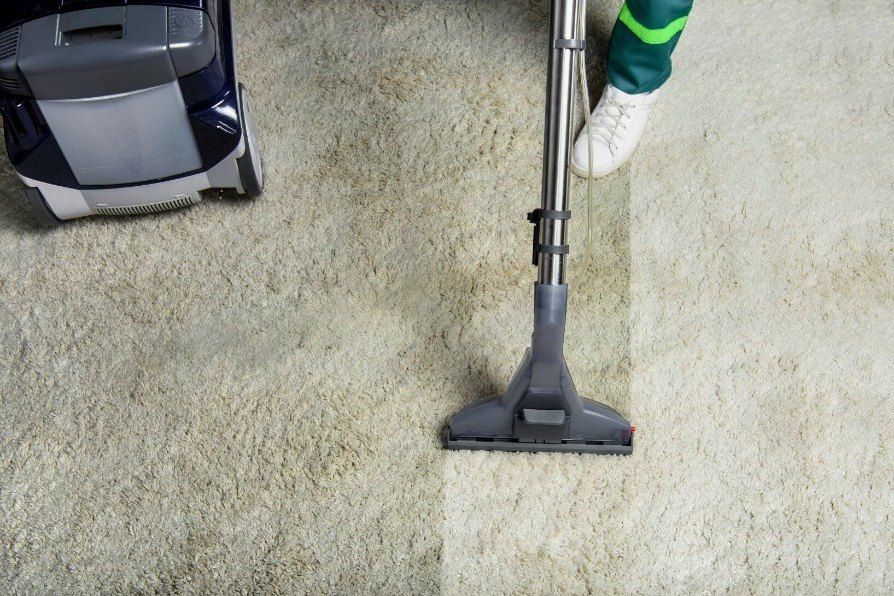 A Person is Using a Vacuum Cleaner to Clean a Carpet — Carpet Pro Care in Goonellabah, NSW