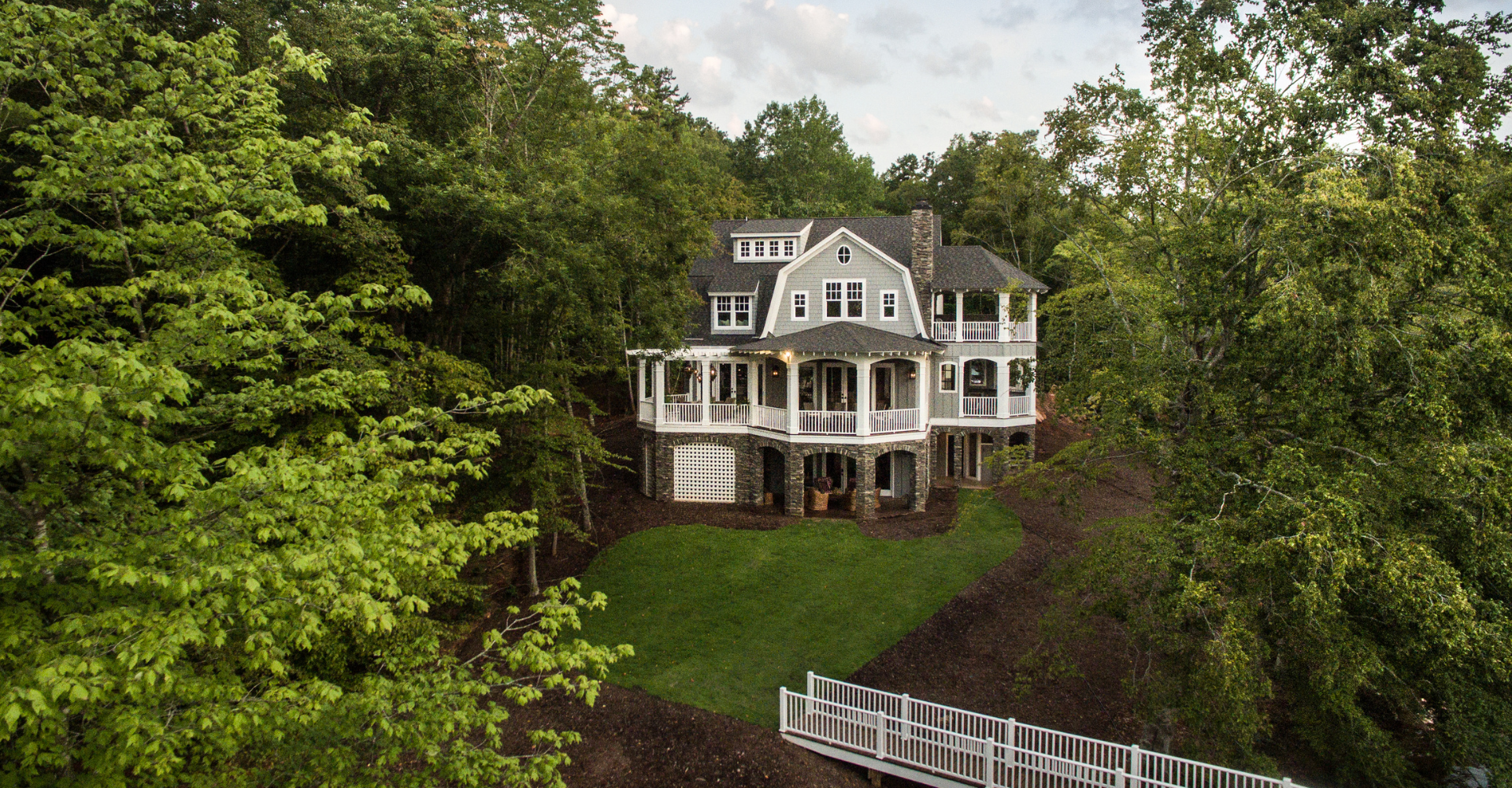 An aerial view of a large white house surrounded by trees.