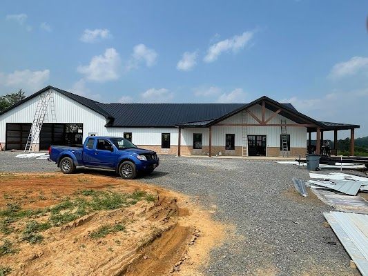 A blue truck is parked in front of a house under construction.