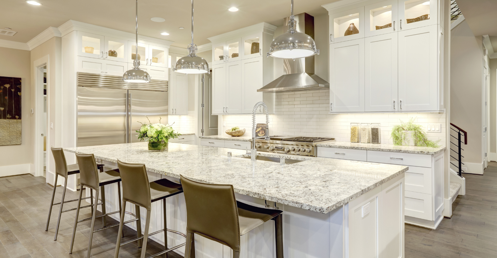 A kitchen with white cabinets , granite counter tops , and stainless steel appliances.