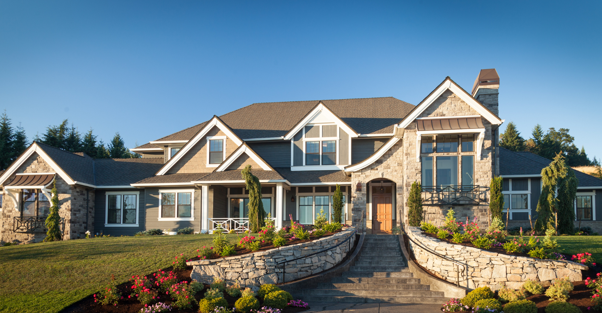 A large house with a stone wall in front of it