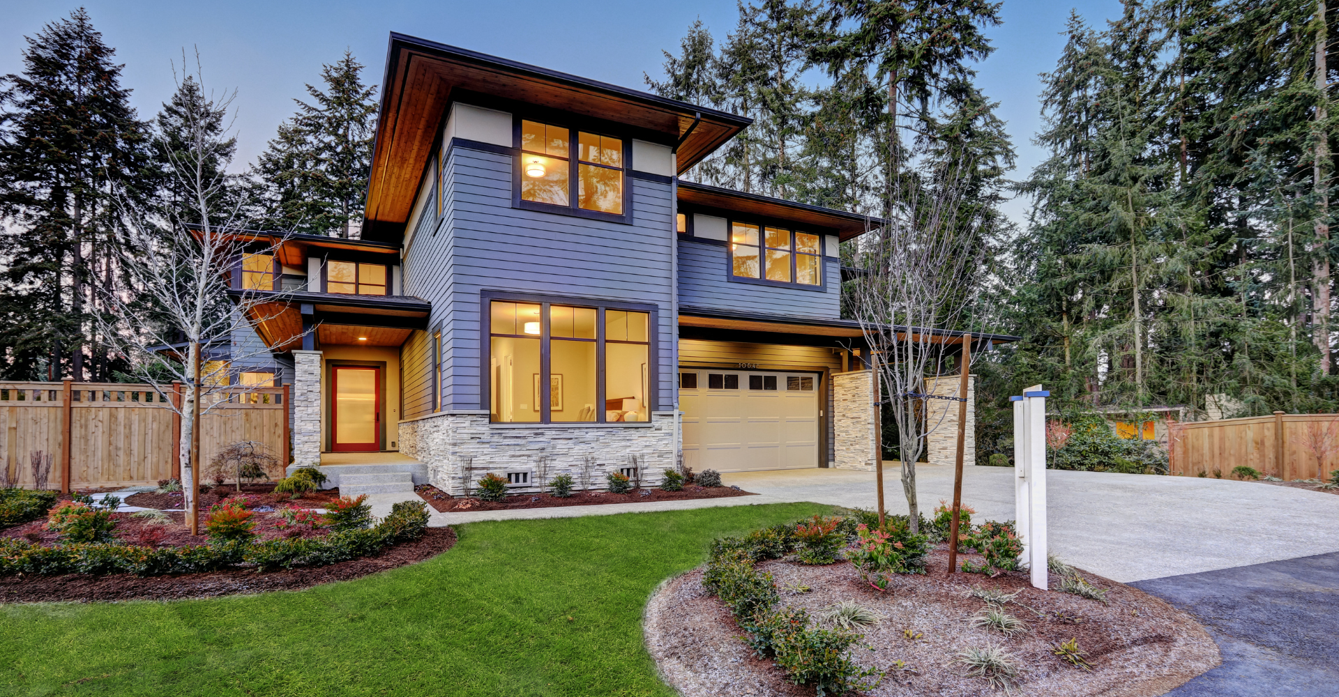 A large house with a lot of windows is surrounded by trees.