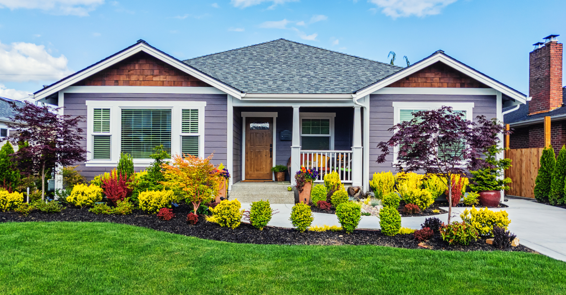 A purple house with a large lawn in front of it.